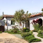 a front view of a house with a yard and a garden
