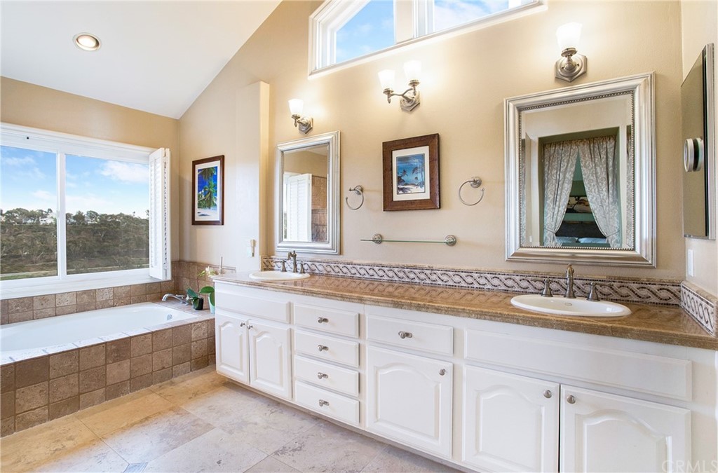 16 Bethany Laguna Niguel, CA 92677 - Photo 25 of 38 a bathroom with double vanity sinks a large mirror and a bathtub