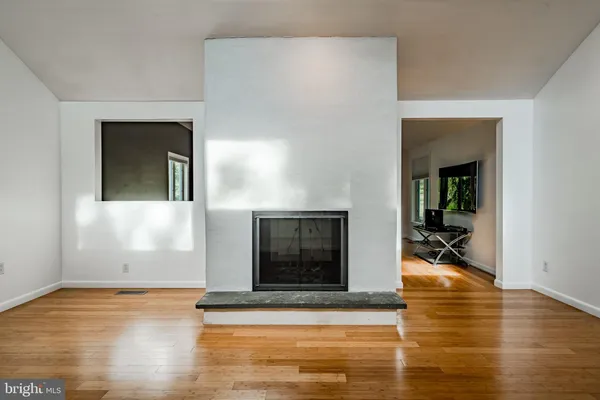 a view of a livingroom with wooden floor and a fireplace