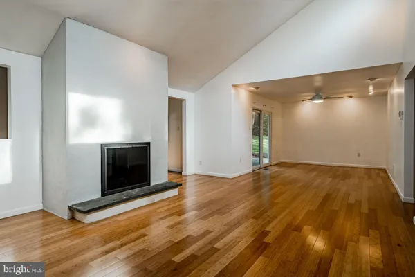 a view of empty room with wooden floor and fireplace