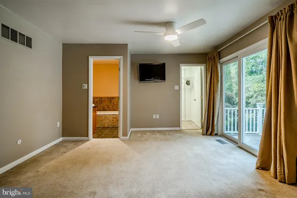 an empty room with windows a fireplace and wooden floor