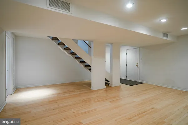 a view of a livingroom with wooden floor and a ceiling fan