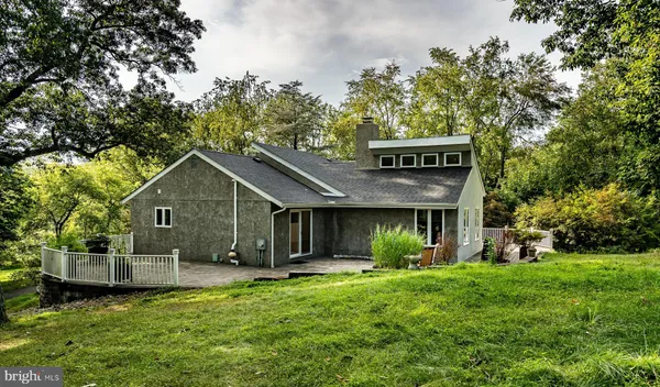 a view of a house with a yard plants and large trees