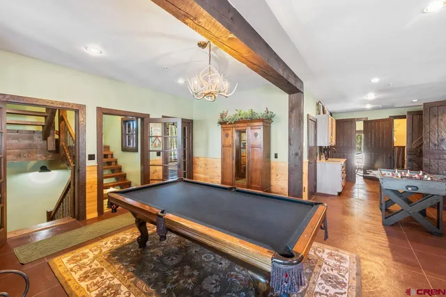 a living room with furniture pool table and a large window