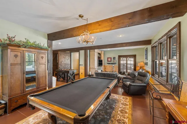 a room with furniture pool table and glass windows