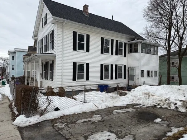 a front view of a building with snow on the road