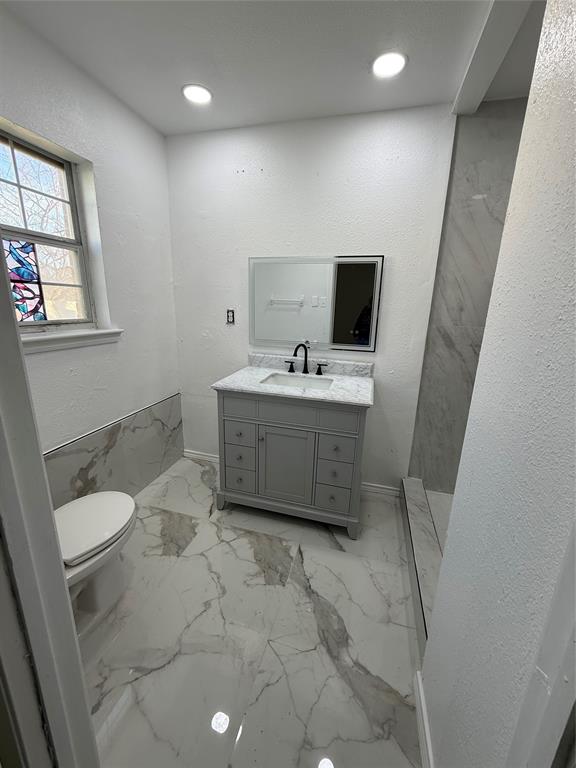 2529 Rutgers Drive Irving, TX 75062 - Photo 3 of 38 a spacious bathroom with a toilet sink and mirror