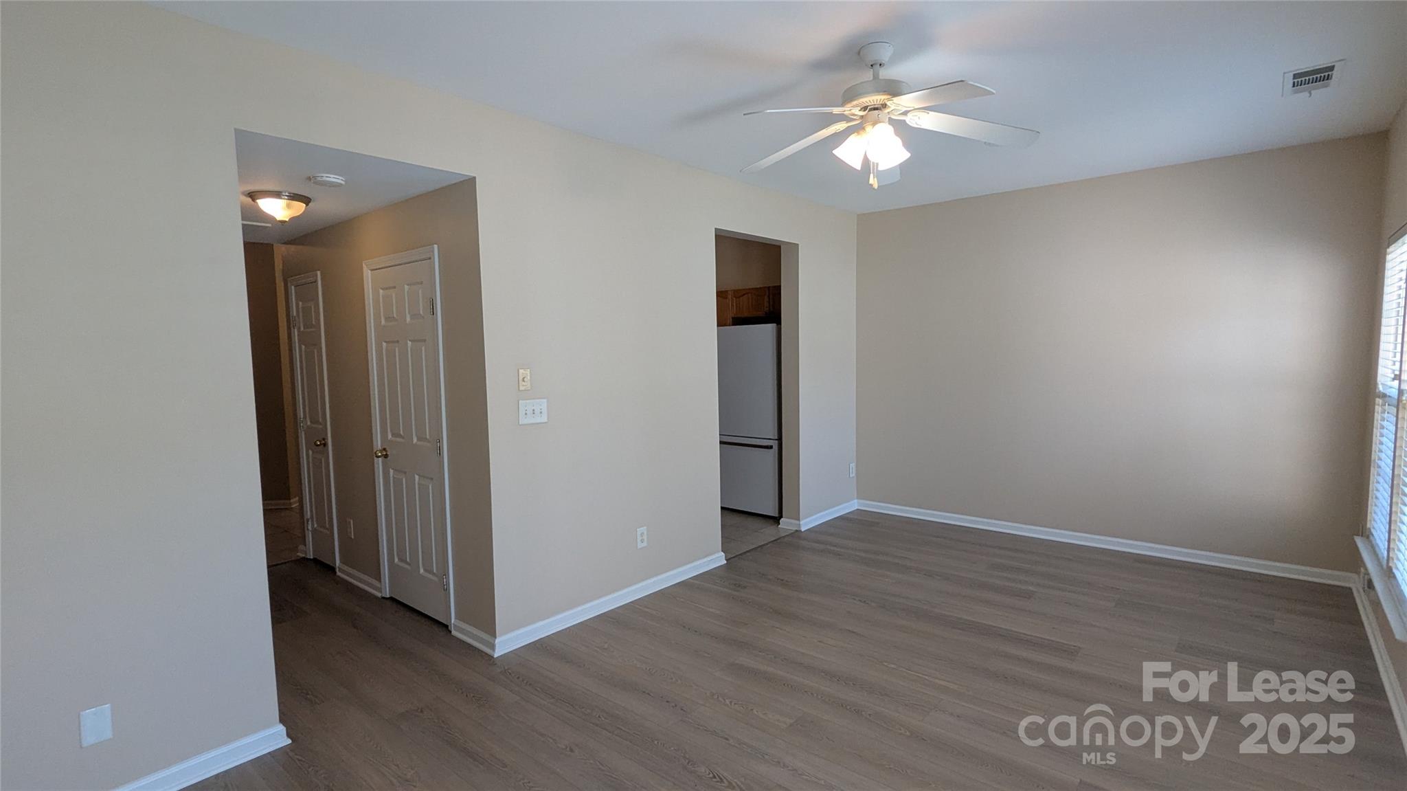 4934 Prosperity Ridge Road Charlotte, NC 28269 - Photo 8 of 15 an empty room with wooden floor and a ceiling fan