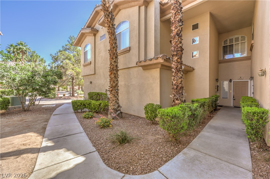 2050 West Warm Springs Road, Unit 1421 Henderson, NV 89014 - Photo 6 of 45 A graceful entry leads to this stucco residence, framed by mature palms and neatly trimmed hedges.