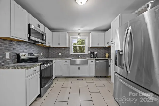 a kitchen with a sink a refrigerator and cabinets