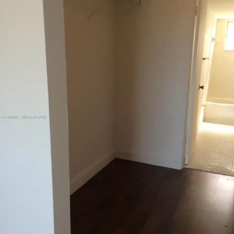 a view of a small space with wooden floor and a window