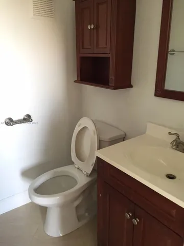 a bathroom with a toilet a sink and mirror