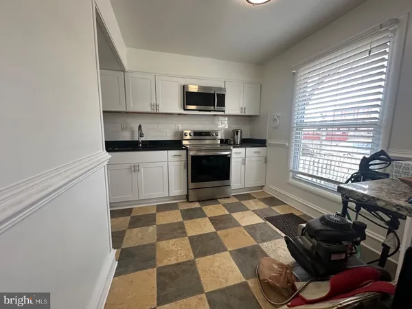 a kitchen with a stove a sink and a microwave