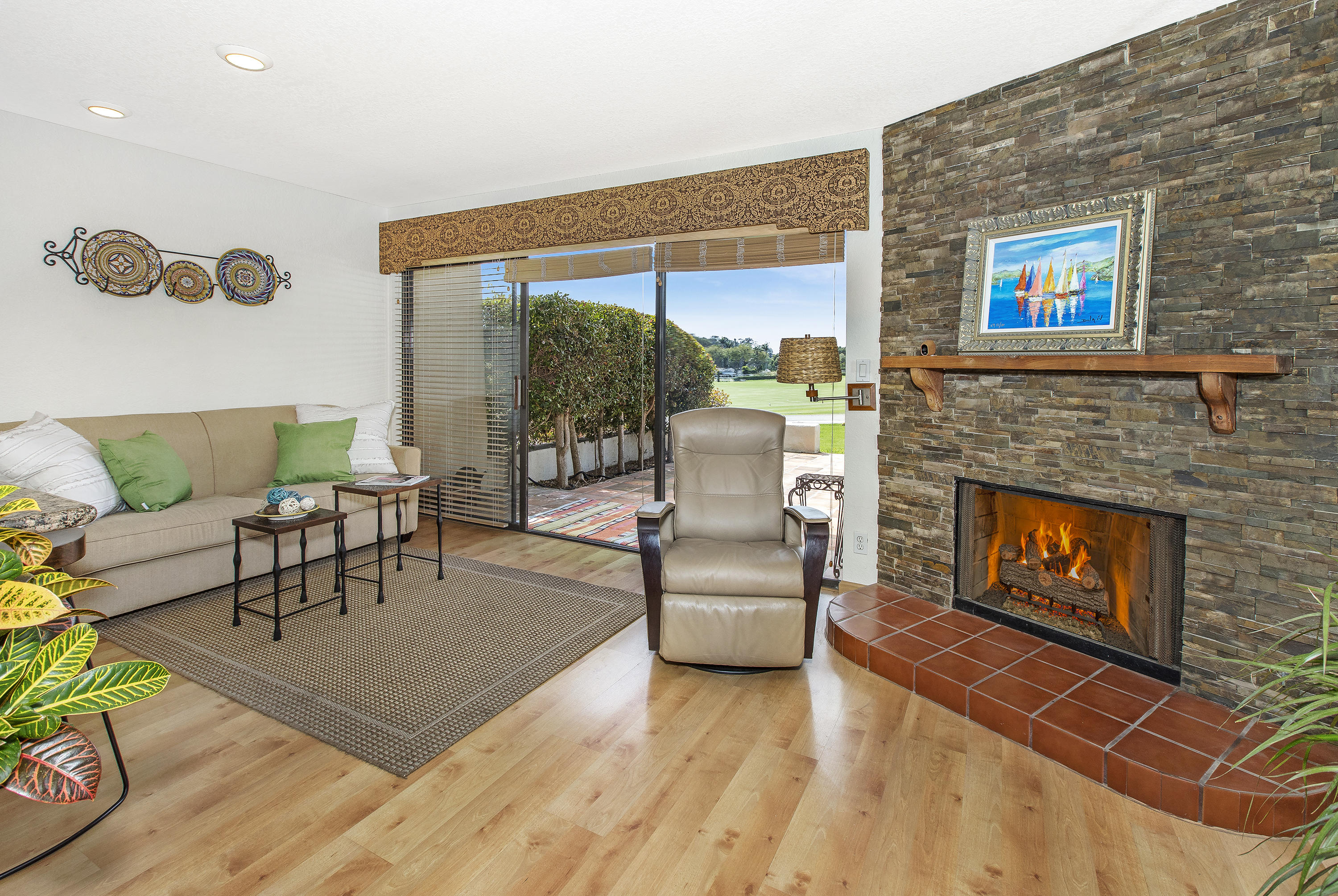 a living room with furniture a fireplace and a floor to ceiling window