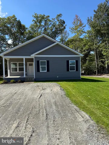 a front view of a house with yard and green space