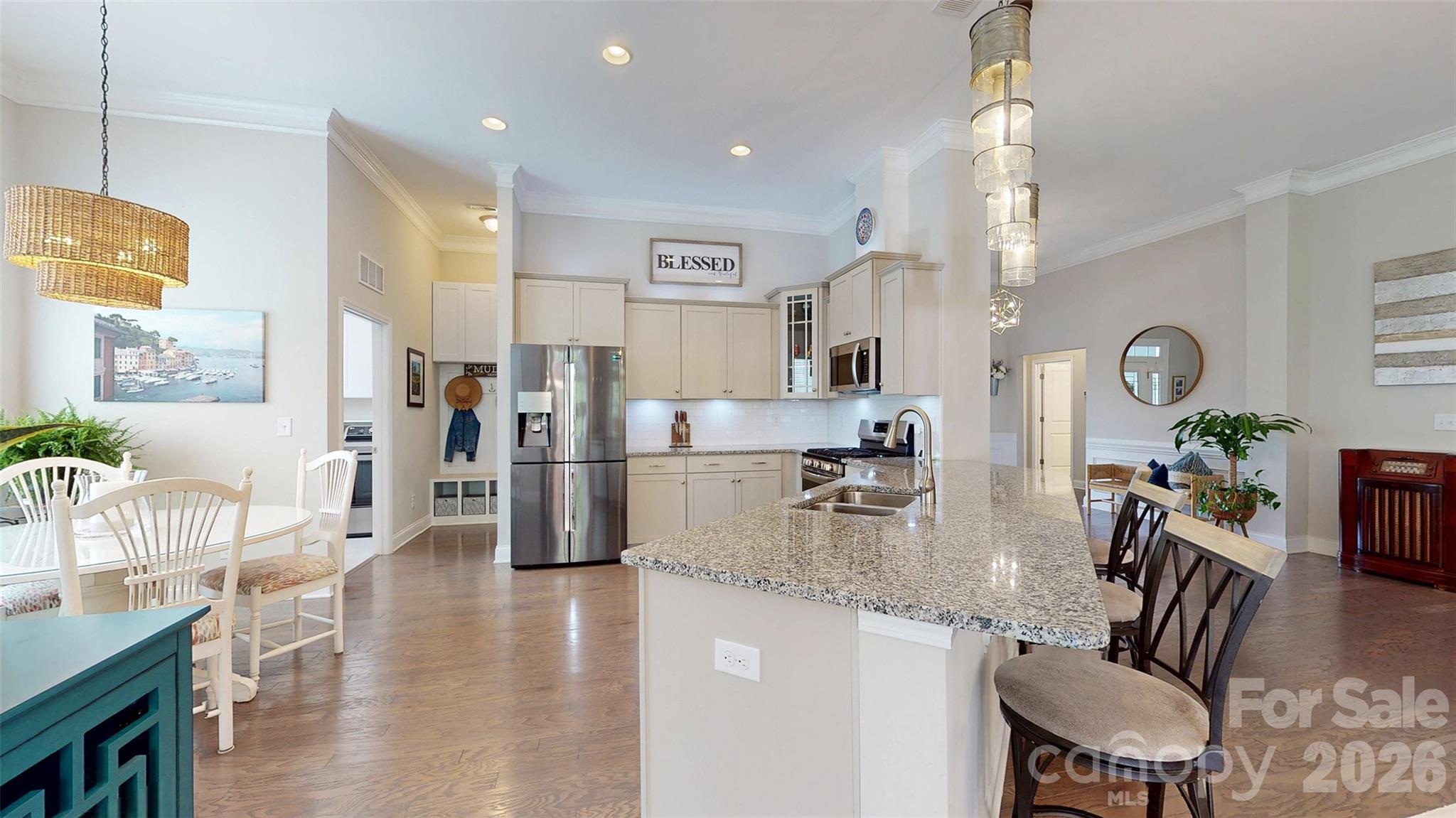 3036 Bridgewater Street Lancaster, SC 29720 - Photo 11 of 41 a kitchen with stainless steel appliances granite countertop a refrigerator a stove a sink a dining table and chairs with wooden floor