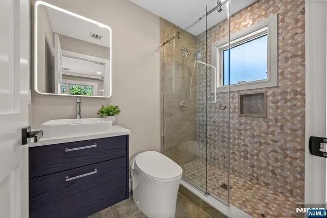 a bathroom with a sink a toilet and shower