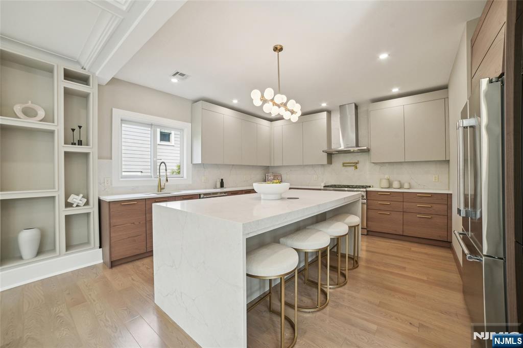 326 Northern Parkway Ridgewood, NJ 07450 - Photo 24 of 30 a kitchen with kitchen island granite countertop a sink cabinets and wooden floor