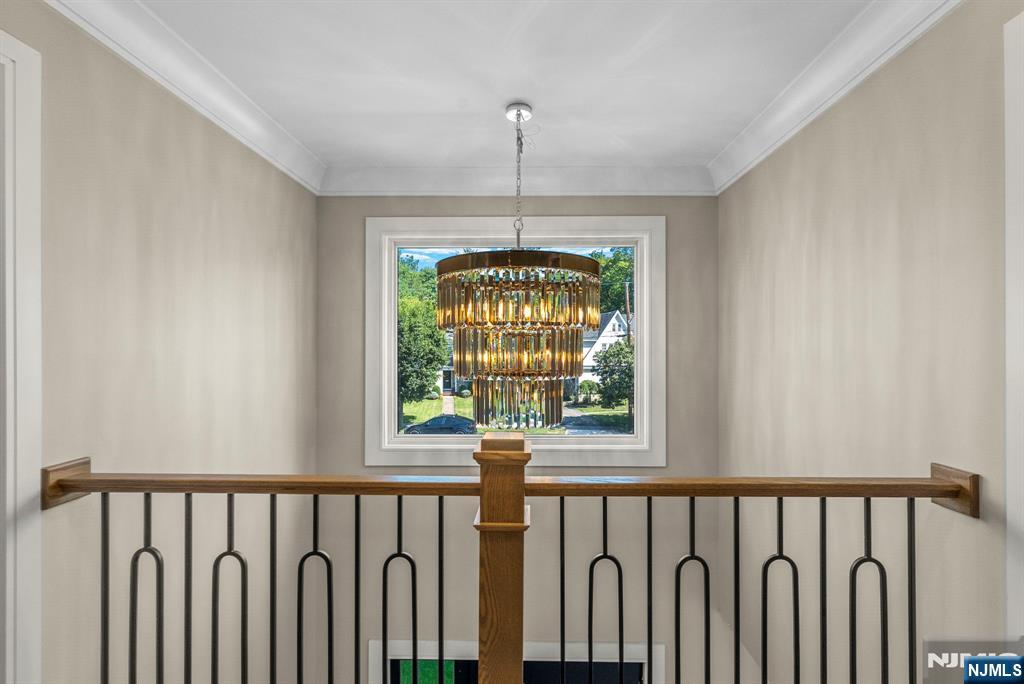326 Northern Parkway Ridgewood, NJ 07450 - Photo 4 of 30 a hallway with wooden floor a chandelier and a window