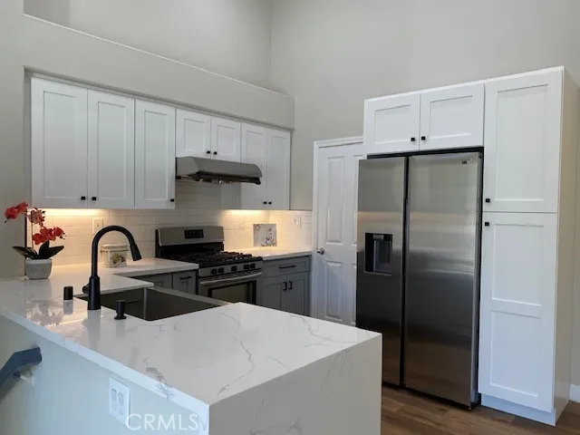 a kitchen with a refrigerator a sink a stove and cabinets