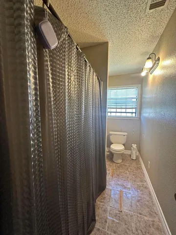 a bathroom with a toilet a sink and shower