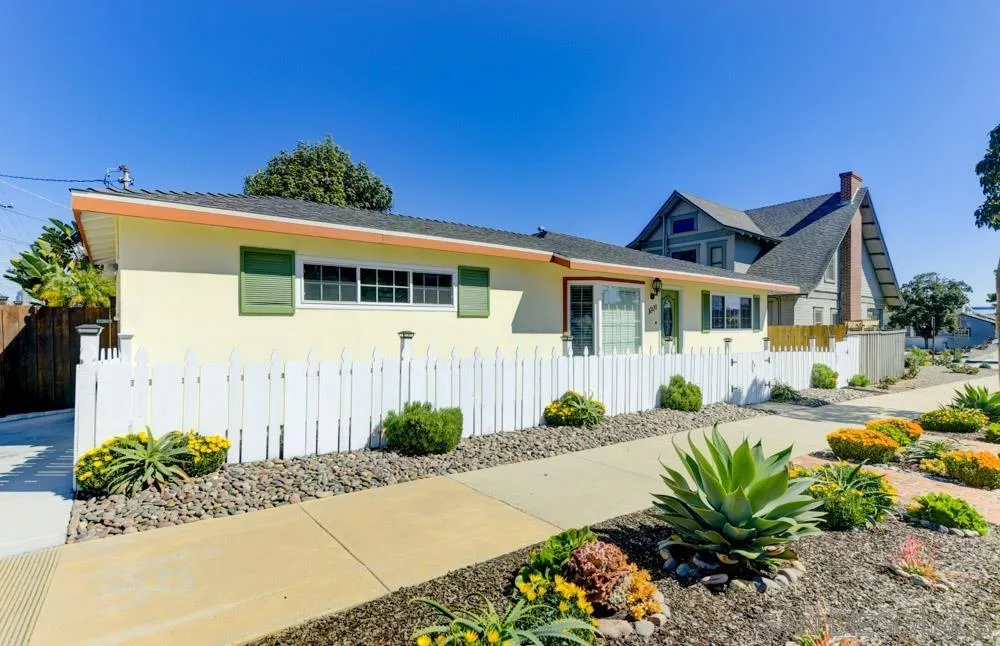 a front view of a house with a yard and potted plants