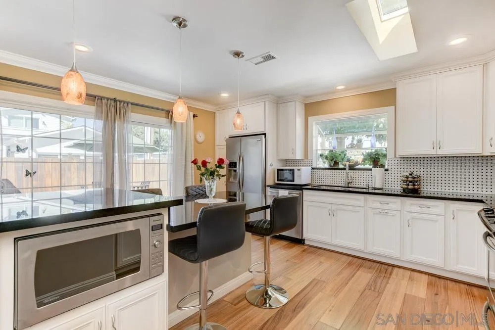 1221 4th Street Coronado, CA 92118 - Photo 19 of 24 a kitchen with granite countertop appliances cabinets and a counter top space
