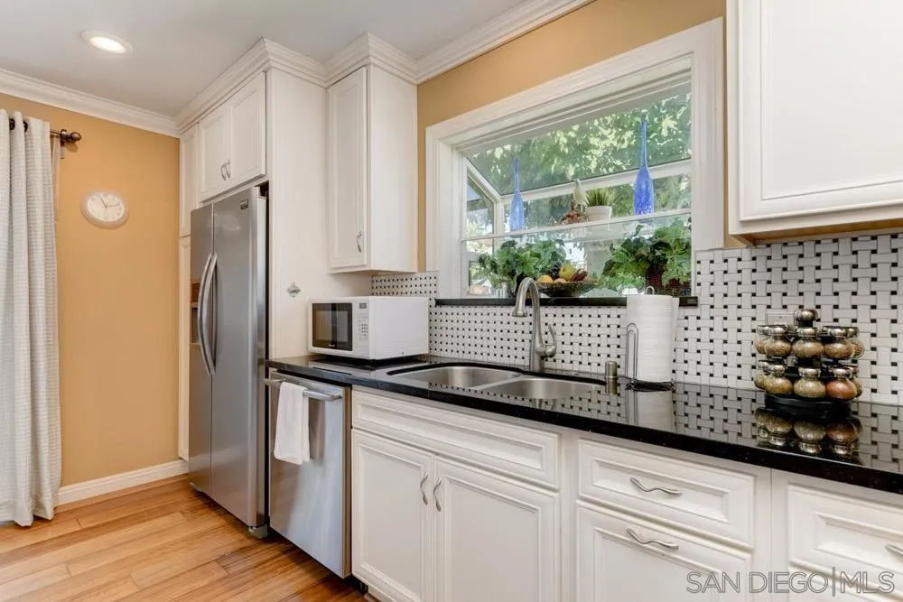 1221 4th Street Coronado, CA 92118 - Photo 20 of 24 a kitchen with stainless steel appliances granite countertop a refrigerator and a sink