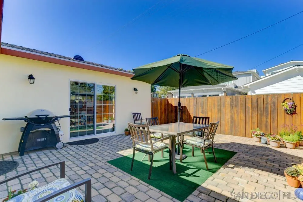 1221 4th Street Coronado, CA 92118 - Photo 10 of 24 a patio with a table and chairs under an umbrella