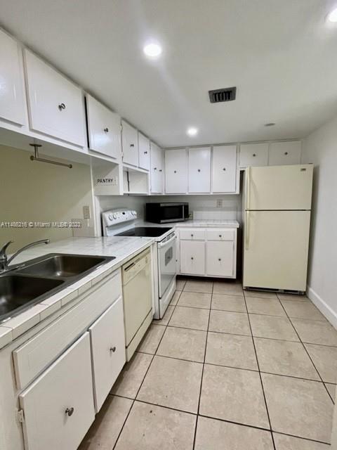 14155 Southwest 87th Street, Unit E310 Miami, FL 33183 - Photo 2 of 13 a kitchen with cabinets and white appliances