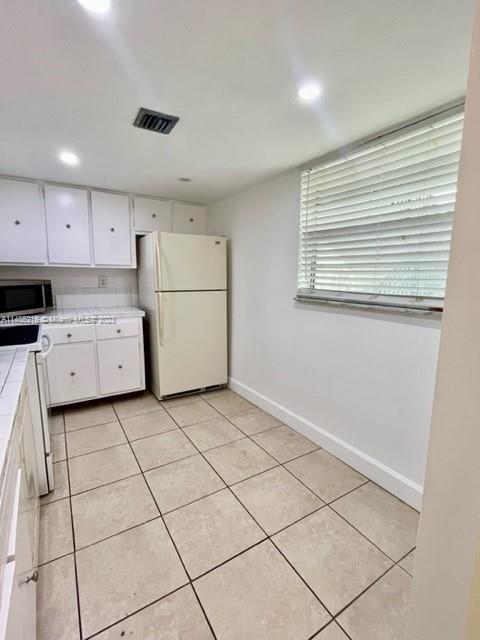 14155 Southwest 87th Street, Unit E310 Miami, FL 33183 - Photo 3 of 13 a kitchen with a stove a sink and a refrigerator