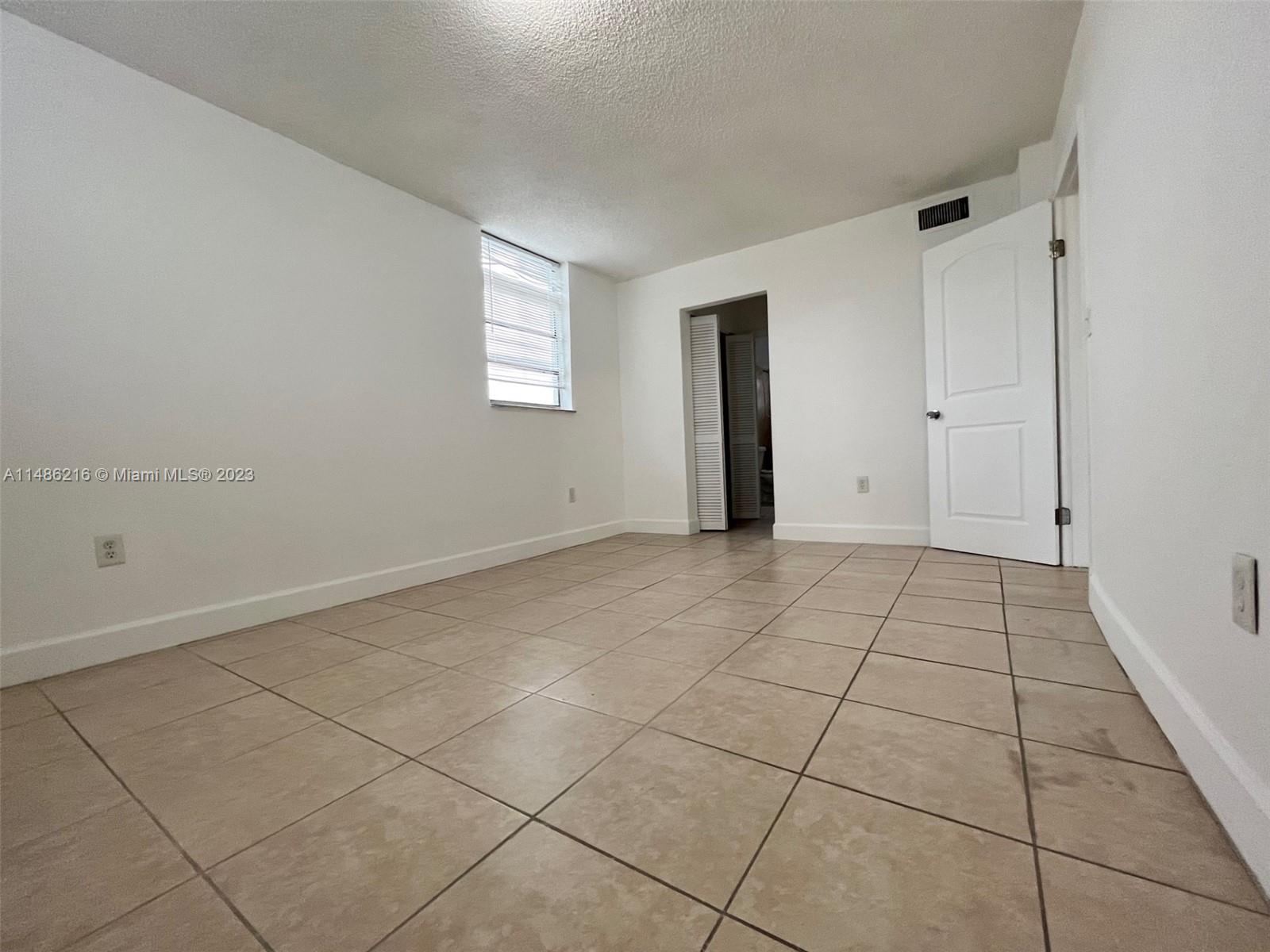 14155 Southwest 87th Street, Unit E310 Miami, FL 33183 - Photo 7 of 13 a view of an empty room and window