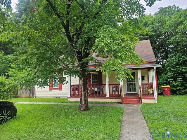 a front view of a house with a garden and trees