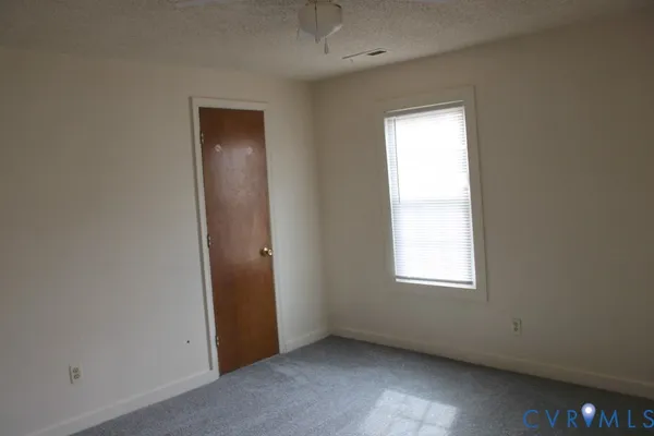 an empty room with windows and closet