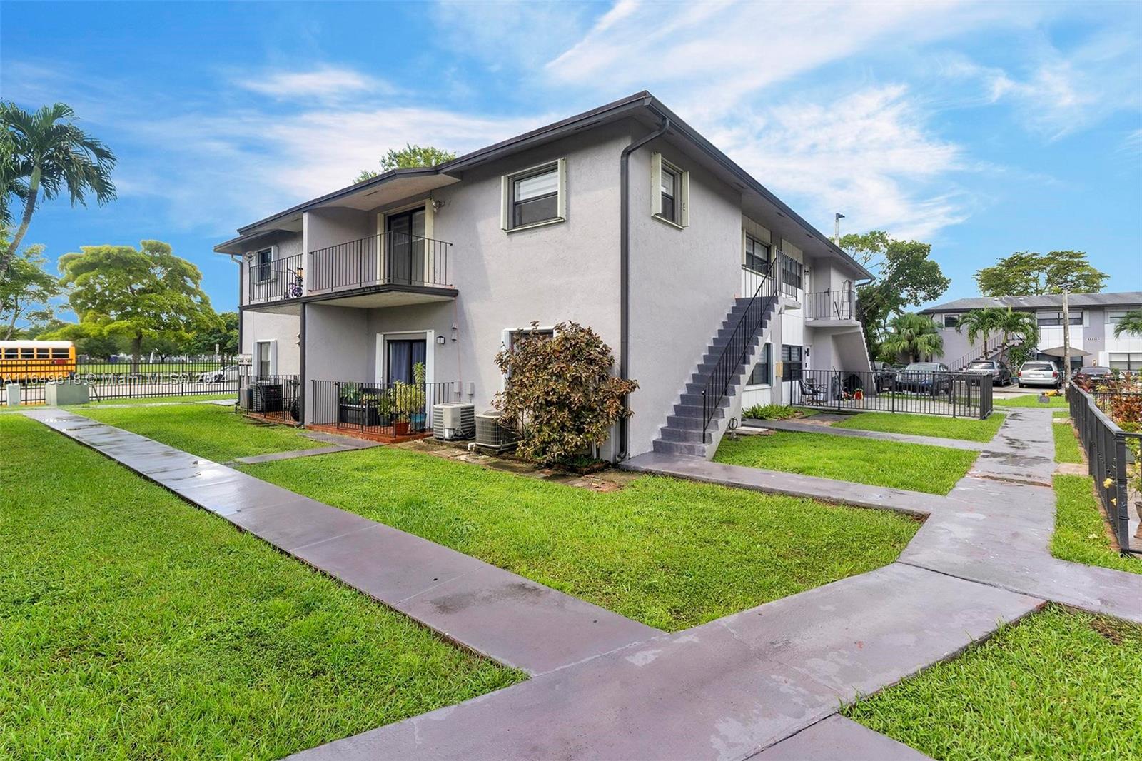 13240 Southwest 17th Lane, Unit 8 Miami, FL 33175 - Photo 12 of 14 a view of a house with a big yard plants and palm trees