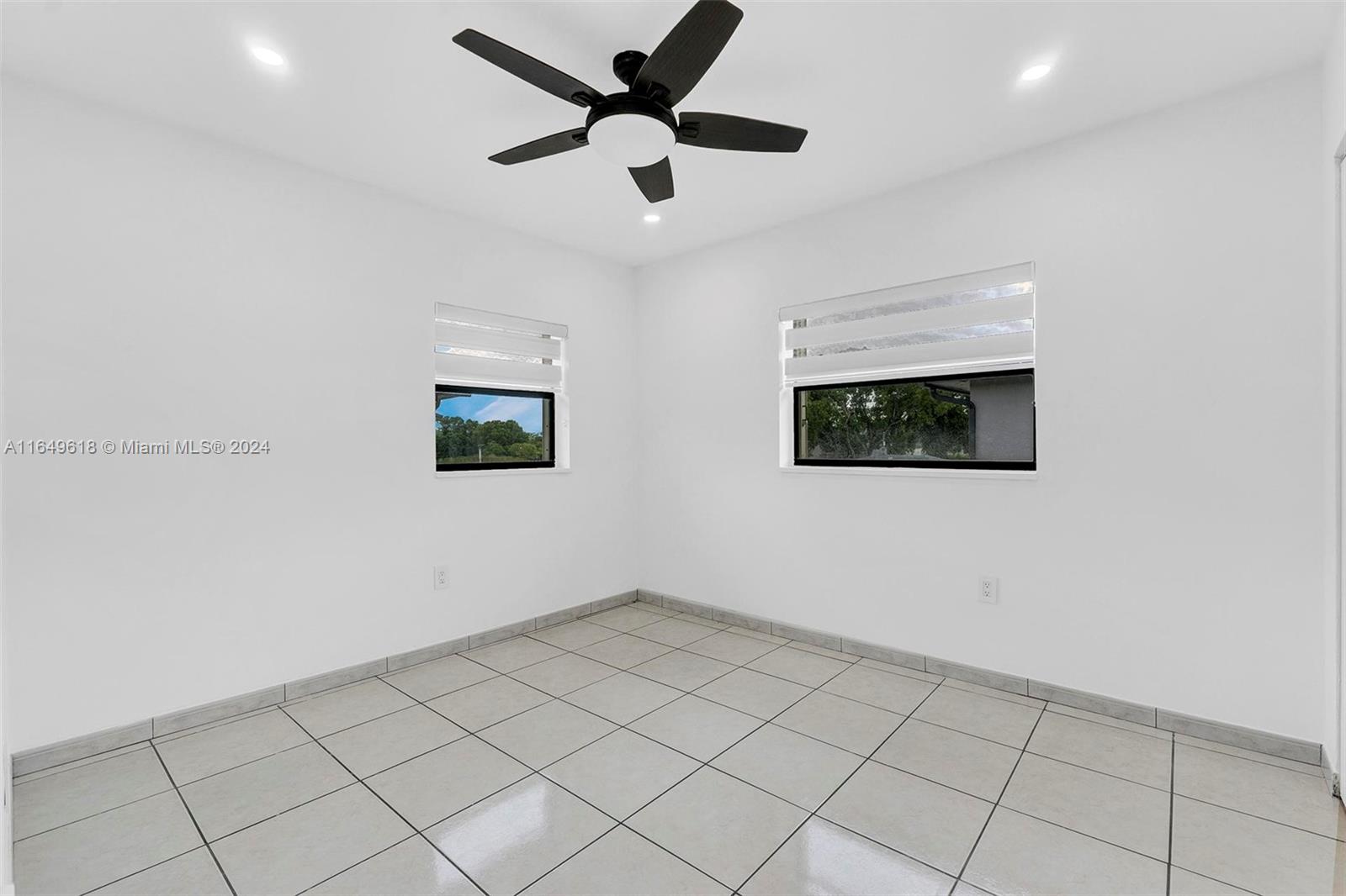 13240 Southwest 17th Lane, Unit 8 Miami, FL 33175 - Photo 7 of 14 an empty room with a ceiling fan and window