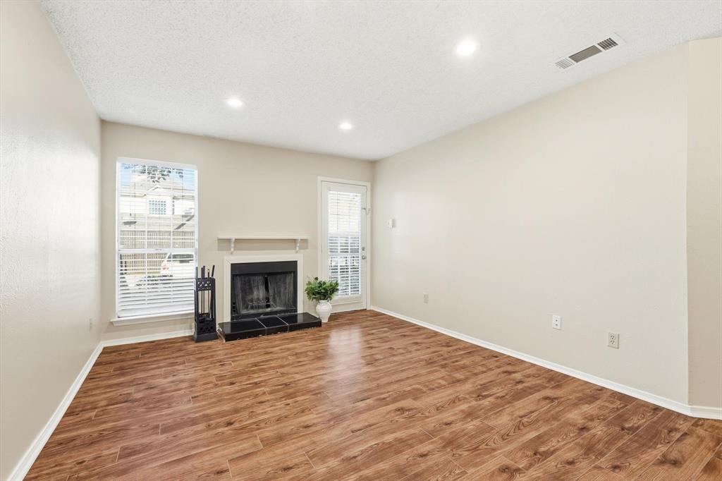 a view of an empty room with a window and fireplace