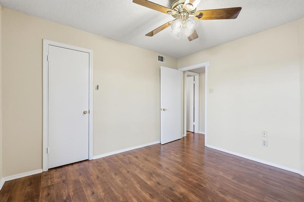 18333 Roehampton Drive, Unit 716 Dallas, TX 75252 - Photo 12 of 24 an empty room with wooden floor fan and windows