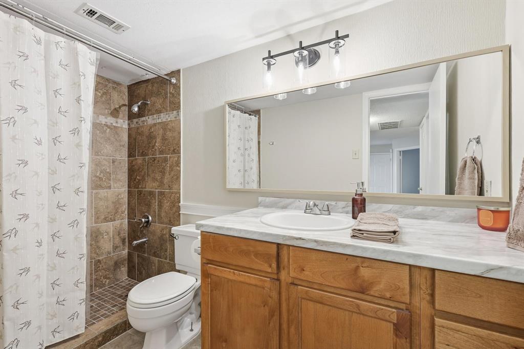 18333 Roehampton Drive, Unit 716 Dallas, TX 75252 - Photo 13 of 24 a bathroom with a sink toilet and shower