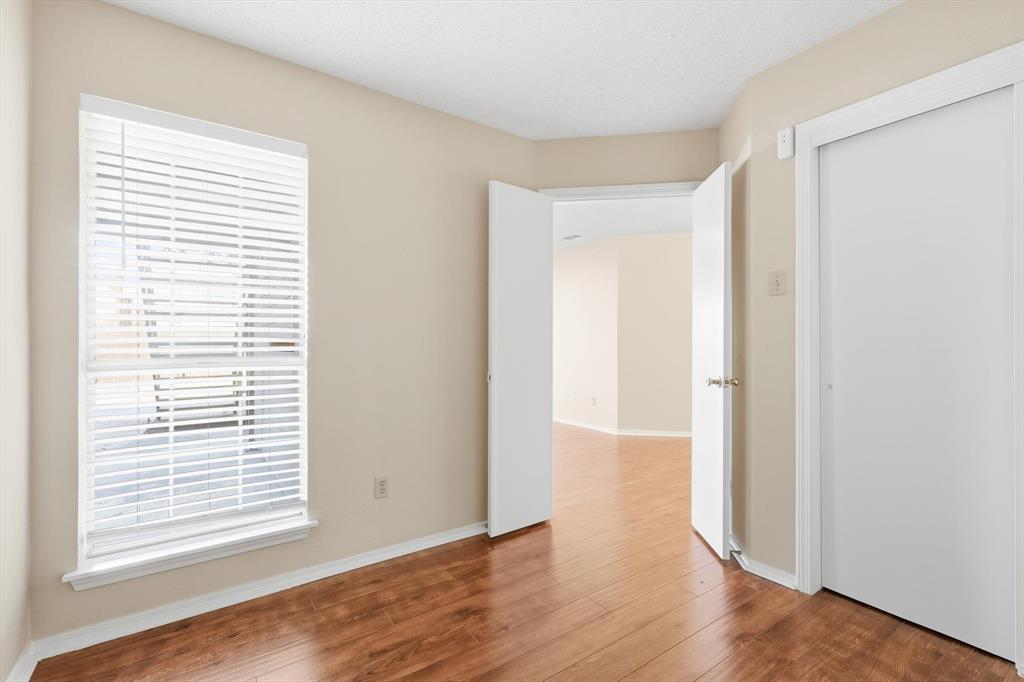 18333 Roehampton Drive, Unit 716 Dallas, TX 75252 - Photo 15 of 24 a view of an empty room with wooden floor and a window