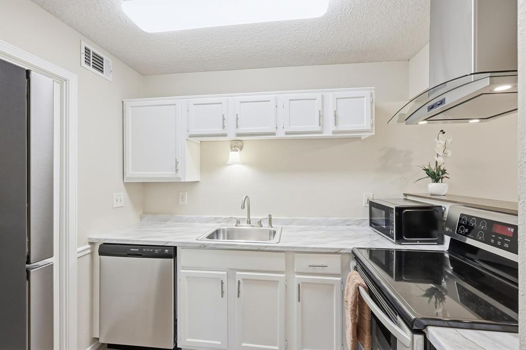 18333 Roehampton Drive, Unit 716 Dallas, TX 75252 - Photo 6 of 24 a kitchen with a sink and cabinets