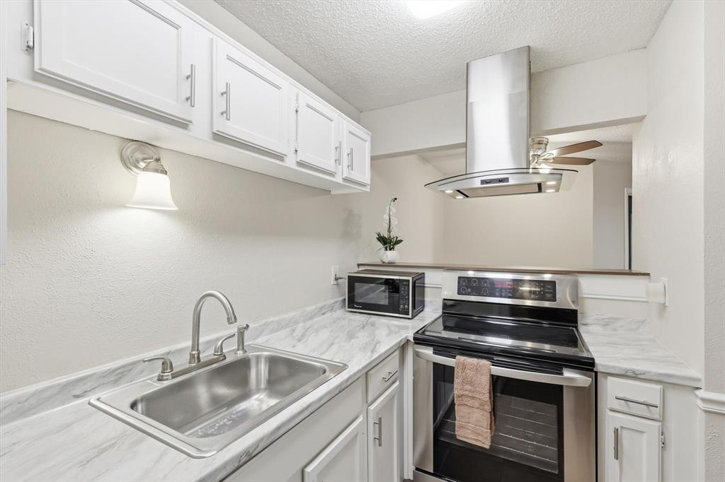 18333 Roehampton Drive, Unit 716 Dallas, TX 75252 - Photo 7 of 24 a kitchen with stainless steel appliances granite countertop a sink stove and cabinets