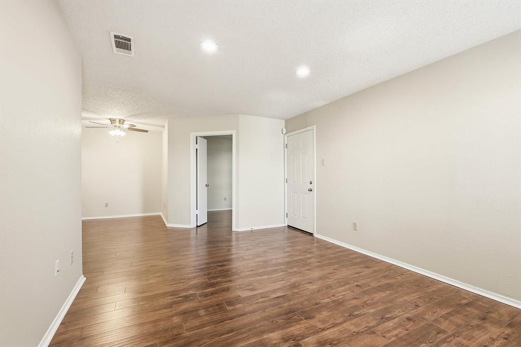 18333 Roehampton Drive, Unit 716 Dallas, TX 75252 - Photo 10 of 24 a view of an empty room with wooden floor and a window