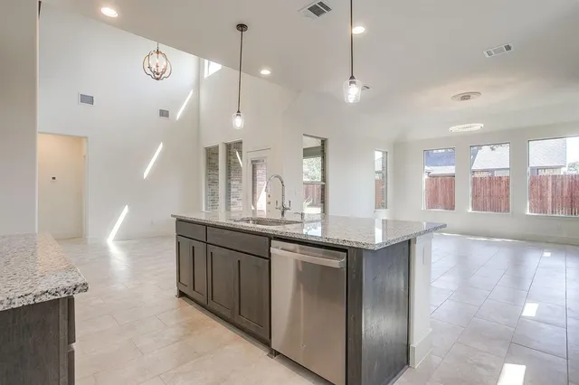 a large kitchen with granite countertop a large kitchen island in the center