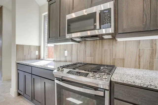 a kitchen with granite countertop a stove and a sink
