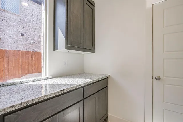 a kitchen with a granite countertop sink and white cabinets