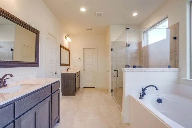 a bathroom with a tub sink and mirror