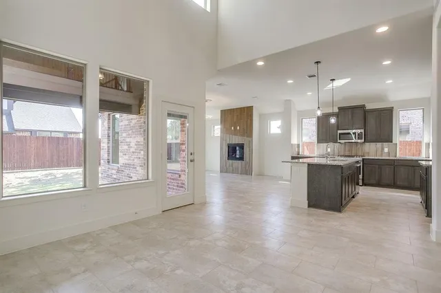 a large kitchen with stainless steel appliances kitchen island granite countertop a large counter top and a stove