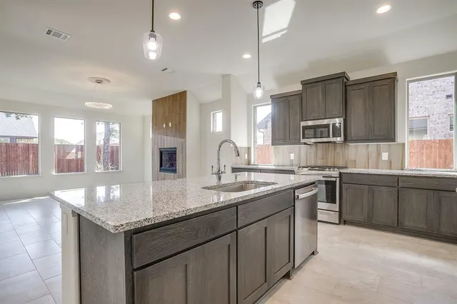 a kitchen with kitchen island granite countertop a sink and white cabinets