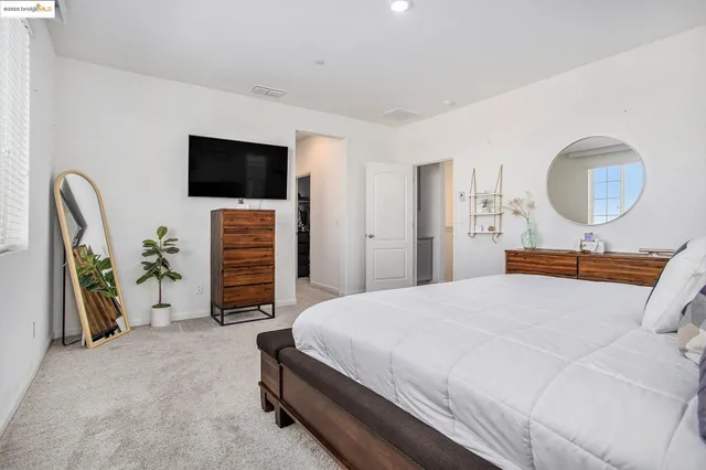 a bedroom with a bed and flat screen tv